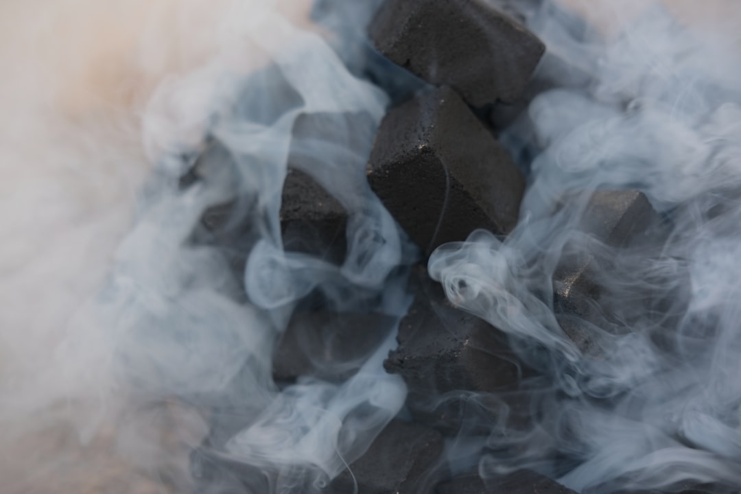 A charcoal bed smouldering under smoke, the everyday reality of a backyard fire
