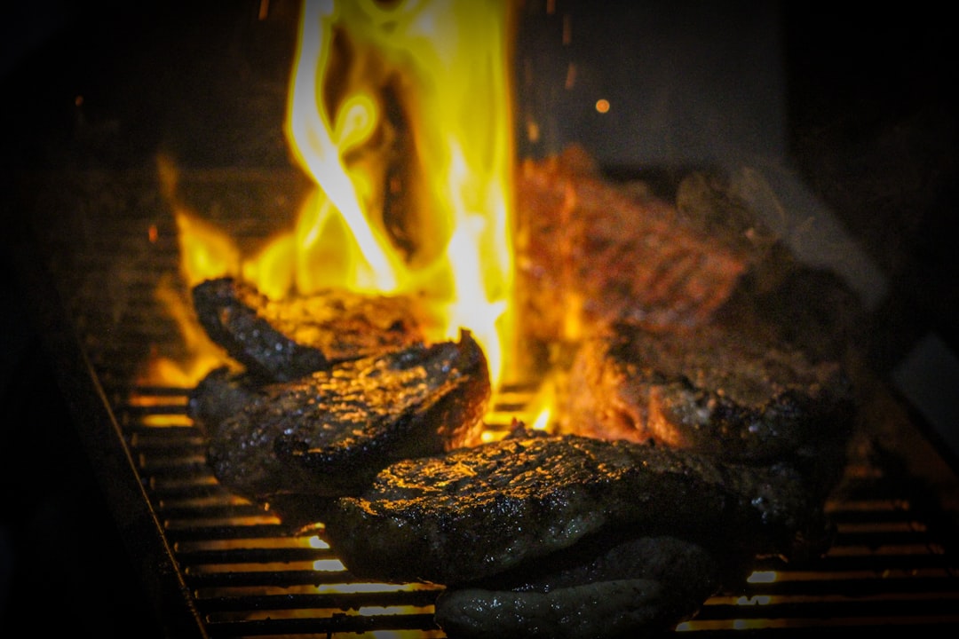 Meat searing over an open charcoal grill, where fuel choice shows up first